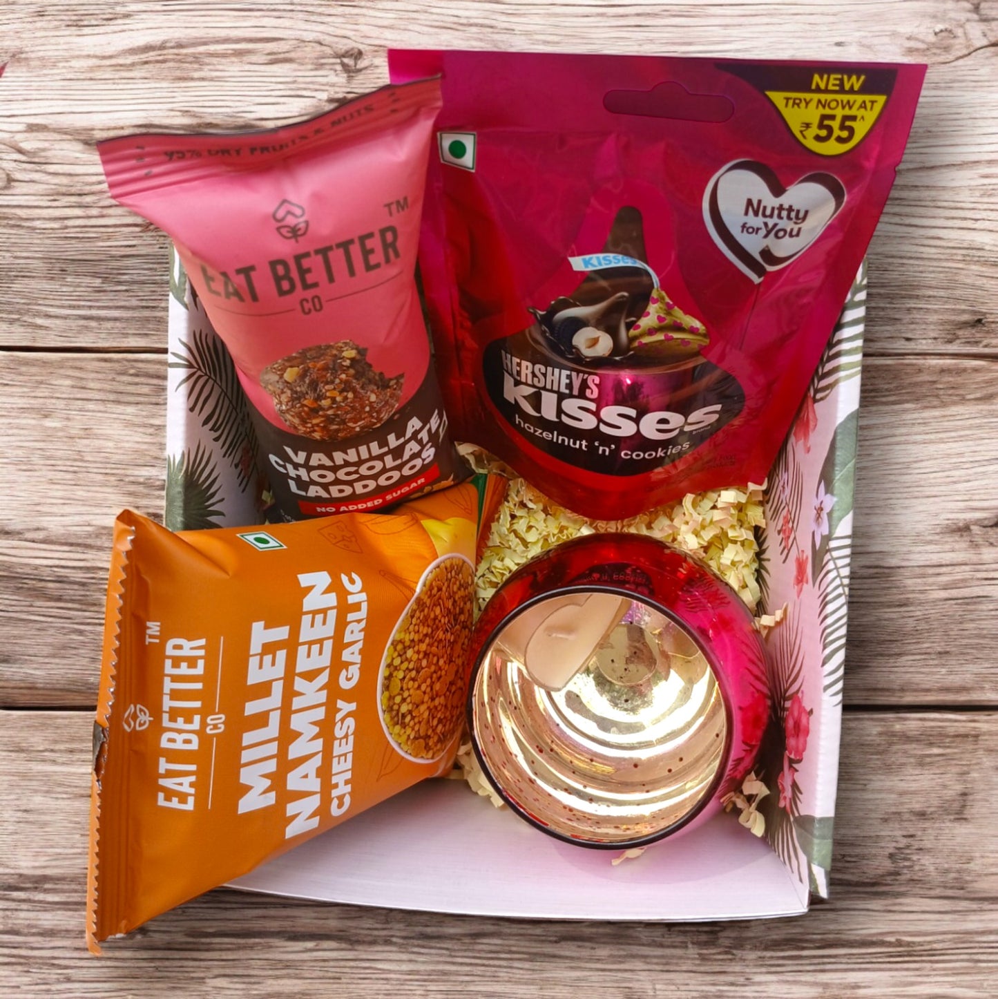 Mini gift hamper box with Candle holder with scented candle, a pack of Hershey's kisses, healthy sweet and savory snack packs