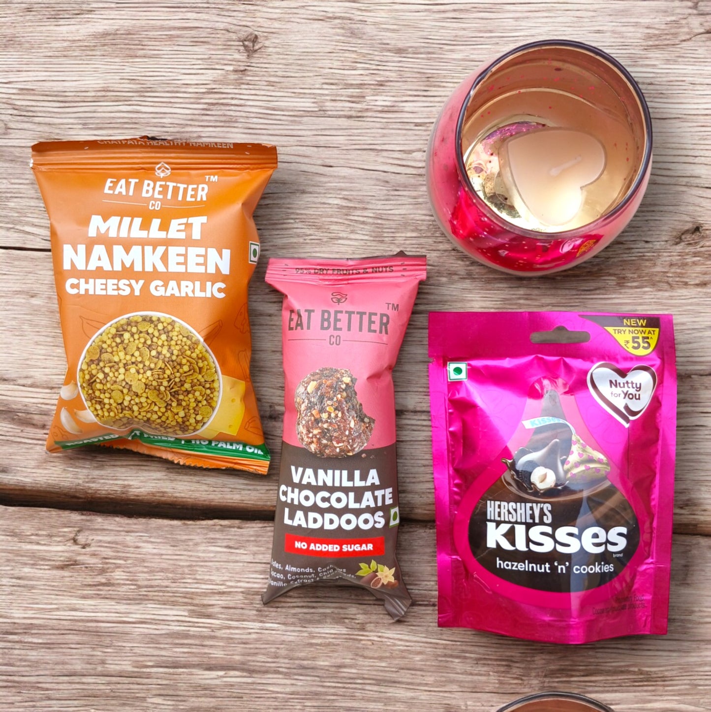 Mini gift hamper box with Candle holder with scented candle, a pack of Hershey's kisses, healthy sweet and savory snack packs